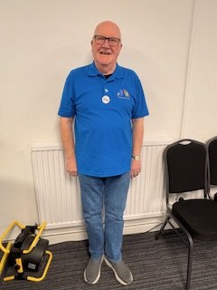 Dominick Brophy, a DSO volunteer, standing in a blue Dementia Sings Out polo shirt