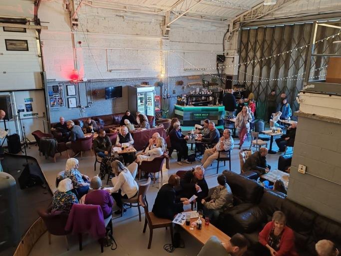 DSO volunteers seated around tables taking part in a quiz afternoon